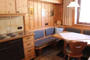 a kitchen with a table and a small table and a table and chairs at Haus STRIEDER - Obergail in Liesing