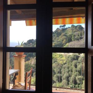 una ventana con vistas a la montaña desde una casa en B&B Il Padrino, en Savoca