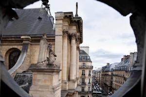 فندق لوندريس سانت أونوريه في باريس: مبنى فيه تمثال في وسط شارع