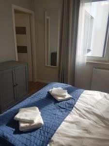 a bedroom with two towels on a bed with a window at Apartament Jasińskiego z ogrodem in Piaseczno