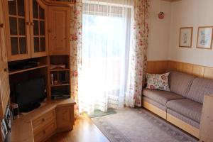 a living room with a couch and a window at Haus STRIEDER - Obergail in Liesing