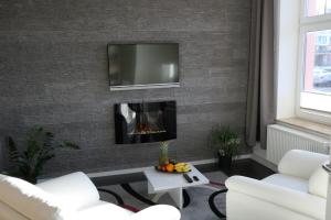 a living room with a fireplace and a tv on a brick wall at Hafenblick in Waren