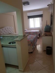 Zimmer mit 2 Betten und einem Waschbecken. in der Unterkunft Flat Hotel Cavalinho Branco in Águas de Lindóia
