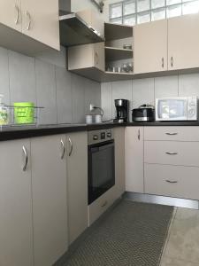 una cucina con armadi bianchi e piano cottura di Apartament Sanda a Turda