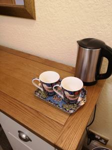 dos tazas de café en una bandeja en un mostrador en The Old Manor at North Somercotes, en North Somercotes