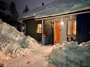 una casa con un montón de nieve delante de ella en Herranterttu Apartments, en Saariselkä