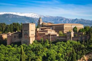 an old building on a hill with mountains in the background at Sierra Nevada Luxury Getaway in Güéjar-Sierra