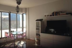 a living room with a glass table and a television at Sierra Nevada Luxury Getaway in Güéjar-Sierra