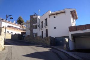 una calle vacía frente a un edificio blanco en Sierra Nevada Luxury Getaway, en Güéjar-Sierra
