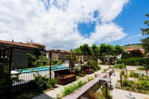 a courtyard with a swimming pool and a garden at Fac & Spera -Hôtel & Spa in Tain-lʼHermitage