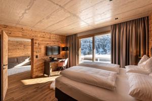 a bedroom with a bed and a desk and a television at Skilodge Oberlech in Lech am Arlberg +20 photos