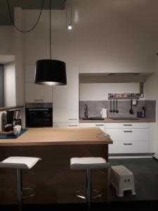 a kitchen with a counter and two stools in it at Vakantiewoning BC Bed en Comfort in Bilzen