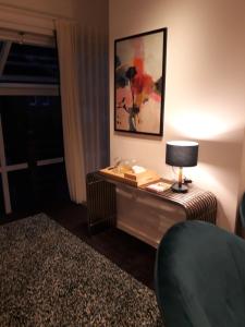 a room with a table with a lamp and a window at Vakantiewoning BC Bed en Comfort in Bilzen