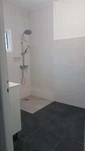 W łazience z podłogą wyłożoną kafelkami znajduje się prysznic. w obiekcie La Kaz Kian w mieście Sainte-Rose