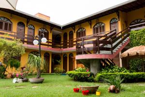 un edificio amarillo con una escalera en el patio en Pousada da Terra, en Natal