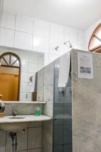 a bathroom with a shower and a sink and a mirror at Pousada da Terra in Natal