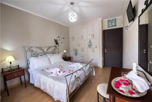 a bedroom with a bed with white sheets and flowers on it at VILLA FAIRIES in Lygia