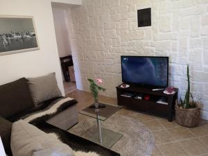 a living room with a couch and a flat screen tv at Paradise apartment - Old town Rab in Rab