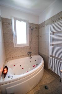 a white bath tub in a bathroom with a window at VILLA FAIRIES in Lygia +11 photos