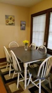 a dining room with a black table and white chairs at Quaint Apartment in Older East Knoxville in Knoxville