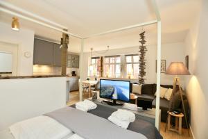 a bedroom with a bed and a tv and a couch at Deine Juist Ferienwohnung Strandburg Juist in Juist