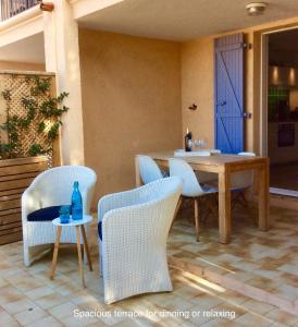 patio con tavolo, sedie e porta blu di Petit Port a Cogolin