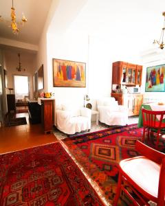 a living room with white furniture and a red rug at Amariglio in Ozieri