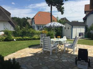 a patio with a table and chairs and an umbrella at Ferienhaus „Sonneninsel“ in Ostseebad Karlshagen