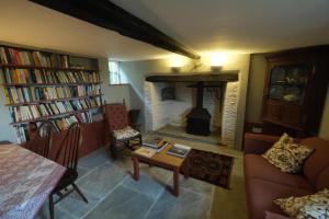 een woonkamer met een open haard, een bank en een tafel bij Chestnut Cottage in Eardisley