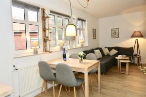 a living room with a table and a couch at Deine Juist Ferienwohnung Strandburg Juist in Juist