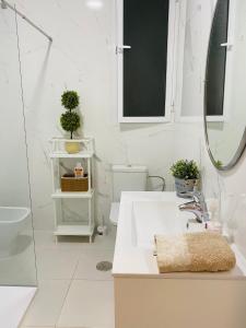bagno bianco con lavandino e specchio di Solymar Beach Premium a Málaga