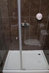 a shower with a glass door in a bathroom at WW Hostel & Suites in Coimbra