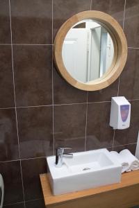 a bathroom with a sink and a mirror at WW Hostel & Suites in Coimbra