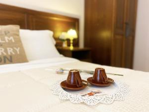 a pair of brown cups on a plate on a bed at Relais Cavour in Rome
