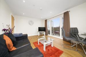 sala de estar con sofá negro y mesa en London Heathrow Living Serviced Apartments by Ferndale, en Stanwell