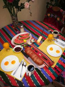 a table with eggs and a breakfast of sausage and fruit at Hotel Chalet in Chichicastenango