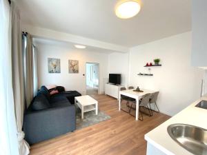 uma sala de estar com um sofá e uma mesa em White Inn - Ferienwohnung mit Terrasse em Mürzzuschlag
