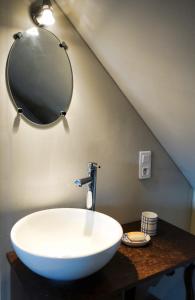 La salle de bains est pourvue d'un grand lavabo blanc et d'un miroir. dans l'établissement Gîte rural Les petites têtes, à Leuze-en-Hainaut