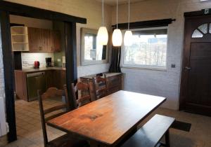 a kitchen with a wooden table and a dining room at Gîte rural Les petites têtes in Leuze-en-Hainaut