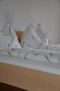 ein Bett mit weißer Bettwäsche und Kissen darauf in der Unterkunft kirchdorf 300 in Bizau