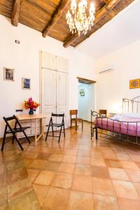 um quarto com uma cama, uma mesa e cadeiras em LA CASA DI NONNA LELLA 1 em Salerno