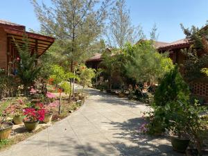 un giardino con fiori e piante su un marciapiede di Trinity Family Inn a Nyaung Shwe