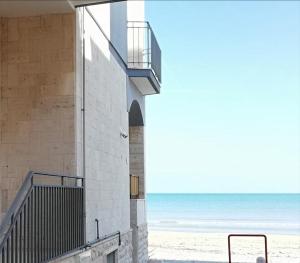 a building with a staircase next to the beach at Blue Sea Apartment in Torre Canne