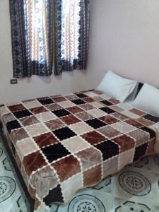 ein Schlafzimmer mit einem karierten Bett in einem Zimmer in der Unterkunft Pharaohs Hotel in Luxor