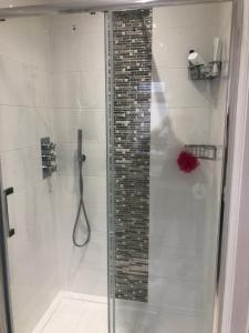 a shower with a glass door in a bathroom at Little Acorns in Saint Albans