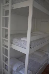 a couple of white bunk beds in a room at WW Hostel & Suites in Coimbra
