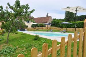 een houten hek naast een zwembad bij gîtes les 7 roches 4 personnes in Le Mas