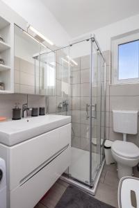 a white bathroom with a sink and a toilet at Apartment Tonka in Barbat na Rabu +19 photos