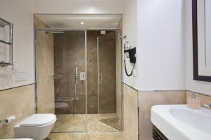 a bathroom with a shower and a toilet and a sink at Duomo Rooms in Milan