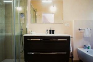 a bathroom with a sink and a glass shower at Boutique Hotel Casa Faccioli in Bologna